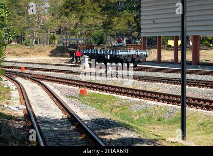 Der Boogie Low-sided Wagon wird auf dem Eisenbahnhof des Stadtbahnhofs geparkt, um darauf zu warten, den Container-Kasten für einen Güterzug zu laden, Vorderansicht mit Stockfoto