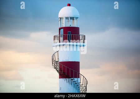 Amsender rot-weißer Leuchtturm mit Wendeltreppe auf der mexikanischen Insel bei Sonnenuntergang aus nächster Nähe Stockfoto