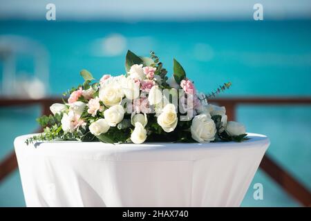Blumenstraußtisch in Weiß und Pink im Mittelpunkt auf dem Cocktailtisch in mexiko Stockfoto