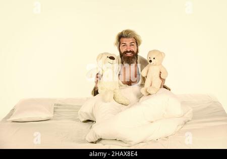 Imaginäre Freunde. Bemühen Sie sich, gute Schlafgewohnheiten zu üben. Niedliches Teddybär Spielzeug. Positive Schlafzimmerumgebung. Bärtige Hipster spielen Spielzeug. Gute Stimmung Stockfoto