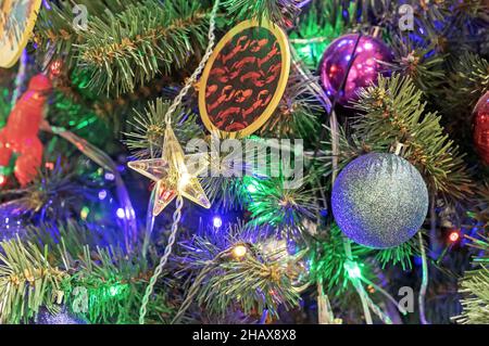 Leuchtendes kleines Sternchen auf einem geschmückten Weihnachtsbaum. Stockfoto