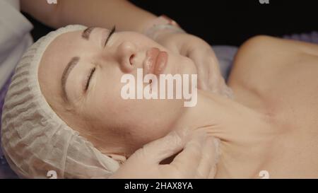 Junge hypnotische Gesichtsfrau erhält Anti-Aging-Gesichtsmassage im Spa-Salon Relax. Wellness Körper Hautpflege Gesicht Schönheitsbehandlung, Verjüngung procedu Stockfoto