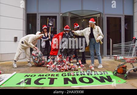 London, Großbritannien 15th. Dezember 2021. Aktivisten des Extinction Rebellion warfen Plastikflaschen und Blechdosen vor dem Hauptsitz von Coca-Cola European Partners in Uxbridge ab. Neben der globalen Umweltverschmutzung beschuldigen die Aktivisten den Limonengiganten der Manipulation, Menschenrechtsverletzungen und Gier der Unternehmen. Kredit: Vuk Valcic / Alamy Live Nachrichten Stockfoto