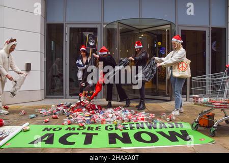 London, Großbritannien 15th. Dezember 2021. Aktivisten des Extinction Rebellion warfen Plastikflaschen und Blechdosen vor dem Hauptsitz von Coca-Cola European Partners in Uxbridge ab. Neben der globalen Umweltverschmutzung beschuldigen die Aktivisten den Limonengiganten der Manipulation, Menschenrechtsverletzungen und Gier der Unternehmen. Kredit: Vuk Valcic / Alamy Live Nachrichten Stockfoto