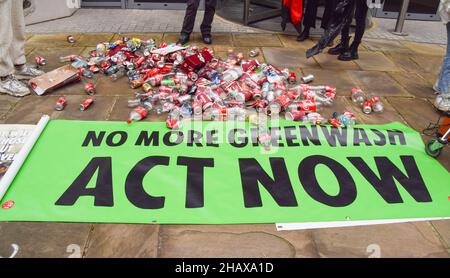 London, Großbritannien 15th. Dezember 2021. Aktivisten des Extinction Rebellion warfen Plastikflaschen und Blechdosen vor dem Hauptsitz von Coca-Cola European Partners in Uxbridge ab. Neben der globalen Umweltverschmutzung beschuldigen die Aktivisten den Limonengiganten der Manipulation, Menschenrechtsverletzungen und Gier der Unternehmen. Kredit: Vuk Valcic / Alamy Live Nachrichten Stockfoto