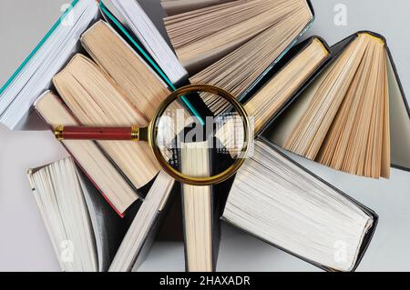 Lupe über verschiedenen Büchern. Konzept von Wissen und Studium. Stockfoto