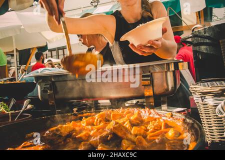 Cheff serviert internationale Fusionskusine am Straßenstand auf dem internationalen Street Food Festival von Odprta kuhna, Open Kitchen Event, in Ljubljana Stockfoto