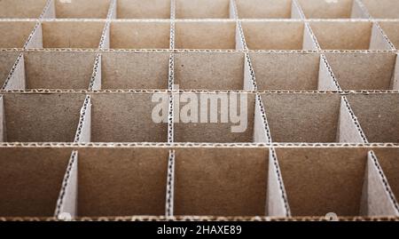 Abstrakter Hintergrund. Quadratische Trennwände aus Pappe aus nächster Nähe. Trennwände für den Transport empfindlicher Glasgegenstände. Stockfoto