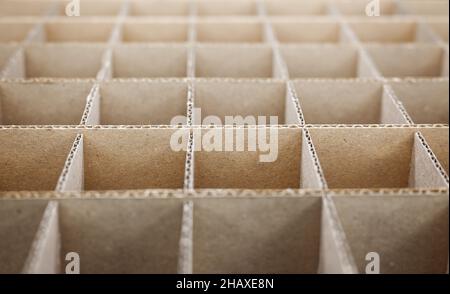 Abstrakter Hintergrund. Quadratische Trennwände aus Pappe aus nächster Nähe. Trennwände für den Transport empfindlicher Glasgegenstände. Geringe Schärfentiefe. Stockfoto