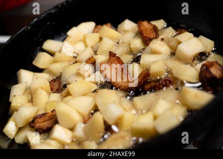 Kochen von Bratkartoffeln mit Schmalz, Knistern in einer Pfanne Stockfoto