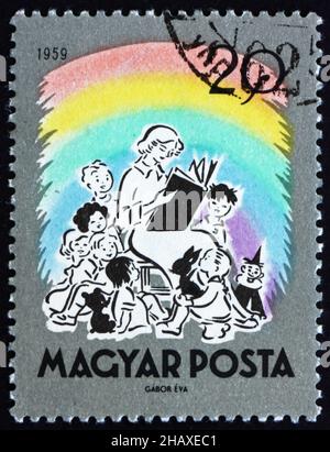 UNGARN - UM 1959: Eine in Ungarn gedruckte Briefmarke zeigt das Lesen von Märchen des Lehrers, um 1959 Stockfoto