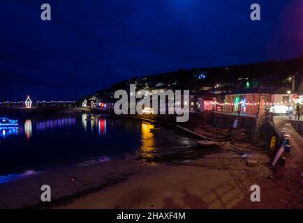 Mousehole,Cornwall,15th. Dezember 2021,Besucher besuchen Mousehole, um die berühmten Weihnachtslichter in Cornwall zu sehen. Bei Flut glitzern die Lichtreflexe über den Hafen. Es gibt alle traditionellen festlichen Lichter einschließlich einer Katze und einer Maus.Quelle: Keith Larby/Alamy Live News Stockfoto