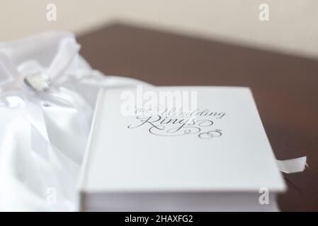 Weiße Ringbox in Buchform mit Text mit der Aufschrift „die Eheringe“ Stockfoto