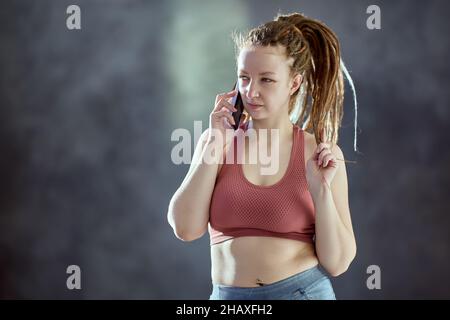 Kaukasische Frau mit geflochtenen Haaren spricht am Telefon. Stockfoto