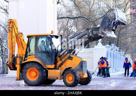 Winterreinigung der Straßen der Stadt. Ein großer Bagger entfernt im Winter frischen Schnee von einer verschneiten Straße. Dnipro City, Dnepr, Ukraine 2020-12-06 Stockfoto