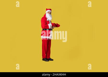 Santa claus gelb funky Stil, Fett schnell weihnachten Winter Spaß glücklich. Hat Opa reif, Lächeln Hände nach vorne zeigt Stockfoto