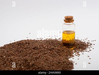 Braune Leinsamen und Leinöl auf weißem Hintergrund. Stockfoto