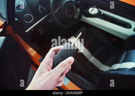 Schlüssel in der Hand von einem Luxusauto auf dem Hintergrund des Autos Stockfoto