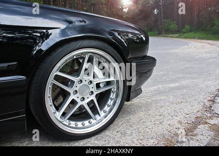 Schwarzes altes schnelles Auto auf dem Hintergrund der Straße Stockfoto