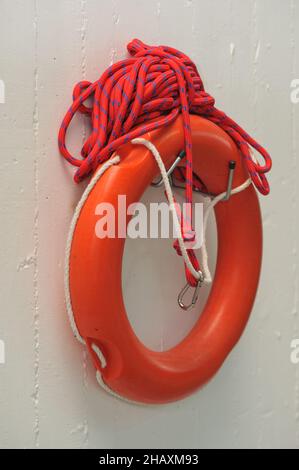Vertikale Aufnahme einer roten Rettungsweste, die an der Wand hängt Stockfoto