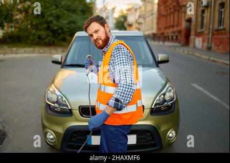 Straßenarbeiter, der das Auto für die Evakuierung vorbereitet Stockfoto