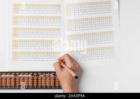 Mentale Mathematik oder mentale Arithmetik. Hand einer Person, die Abakus zur Berechnung verwendet. Lernen, Abacus auf mentalen Mathematik-Kursen zu verwenden Stockfoto