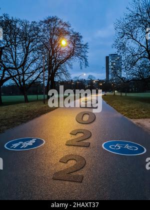 Das Konzept einer Straße für die Geschäftsplanung, das Wort 2022, geschrieben auf der Straße inmitten von Bäumen im Park am Abend, Neujahr 2022 Konzept. Stockfoto