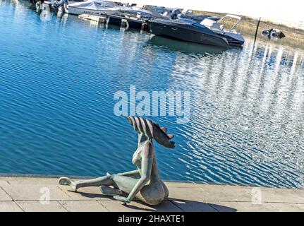 Die Statue einer Meerjungfrau, die im Hafen von Faro, Portugal, sitzt. Stockfoto