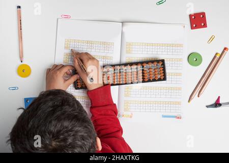 Mentale Mathematik oder mentale Arithmetik. Hand eines kleinen Jungen mit Abakus zur Berechnung. Lernen, Abacus auf mentalen Mathematik-Kursen zu verwenden. Ein Kind, das es tut Stockfoto