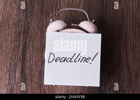 Wecker und Termintext auf Papier. Deadline, Last day, Last Chance Konzepte Stockfoto