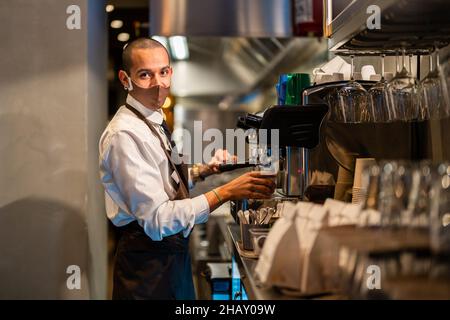 Seitenansicht der flexiblen weiblichen Durchführung Eka Pada Urdhva Dhanurasana Pose beim Üben von Yoga und Reflektieren im Spiegel Stockfoto