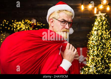 Weihnachtsmann trägt rote Tasche mit Geschenken. Lieferung weihnachtsgeschenke. Werbung für das neue Jahr Stockfoto