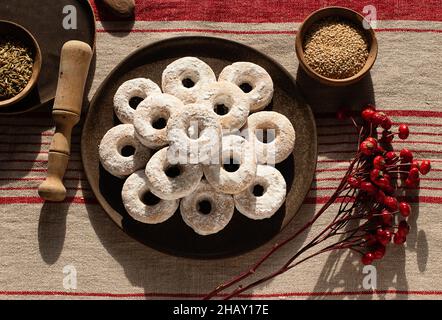 Draufsicht auf weihnachtliche Wein-Donuts auf einem Holztisch, umgeben von Zutaten Stockfoto