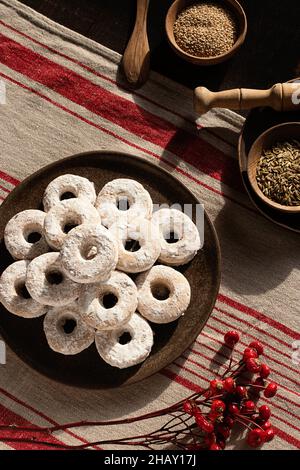 Draufsicht auf weihnachtliche Wein-Donuts auf einem Holztisch, umgeben von Zutaten Stockfoto