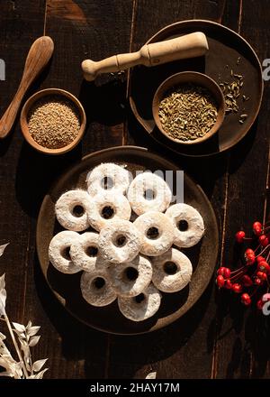 Draufsicht auf weihnachtliche Wein-Donuts auf einem Holztisch, umgeben von Zutaten Stockfoto