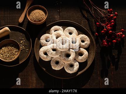 Draufsicht auf weihnachtliche Wein-Donuts auf einem Holztisch, umgeben von Zutaten Stockfoto