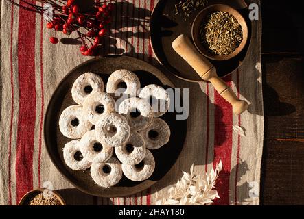 Draufsicht auf weihnachtliche Wein-Donuts auf einem Holztisch, umgeben von Zutaten Stockfoto