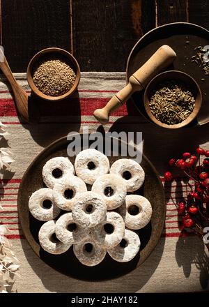 Draufsicht auf weihnachtliche Wein-Donuts auf einem Holztisch, umgeben von Zutaten Stockfoto