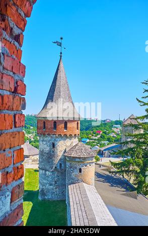 Genießen Sie den Wallspaziergang und den Blick von der Backsteinschlupfloch auf dem kleinen Kommandantenturm und dem hohen Lanckoronska-Turm von Kamianets-Podilskyi Castle, U Stockfoto