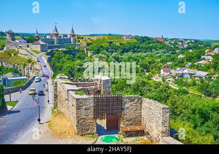 Die steinernen Ruinen der mittelalterlichen Festungsmauer vor der üppig grünen Schlucht des Smotrych-Flusses und des Kamianets-Podilskyi-Schlosses, Ukraine Stockfoto