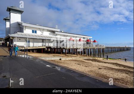 Felixstowe, Suffolk, Großbritannien: Der Felixstowe Pier ist bei Touristen wegen seiner Spielhalle und seines Cafés beliebt. Zwei Personen laufen entlang der Promenade. Stockfoto