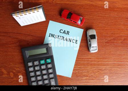 Planungs- und Finanzkonzept. Draufsicht auf Tischkalender, Rechner, Kleinwagen und Papier mit Kfz-HAFTPFLICHTVERSICHERUNG Stockfoto