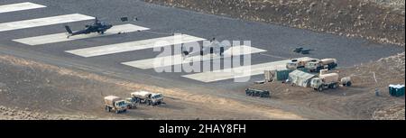 AH-64E Apache-Hubschrauber zugewiesen an 1-229th Angriffsbataillon 'Tigerhaie', 16th Combat Aviation Brigade, bereiten sich auf den Start vom Vorwärts-Bewaffnungs- und Betankungspunkt im Yakima Training Center, Washington, am 10. Dezember 2021 vor. Die Einheit führt eine kombinierte Waffen-Live-Feuer-Übung mit 1st Kampfhubschrauber-Einheit, japanischer Boden-Selbstverteidigungskraft als Teil der Übung Rising Thunder 21 durch. (USA Foto der Armee von Capt. Kyle Abraham, 16th Combat Aviation Brigade) Stockfoto