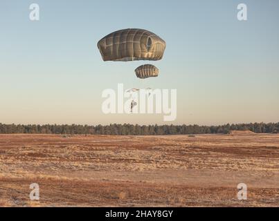 Fallschirmjäger der US-Armee, die der Airborne Division 82nd zugewiesen sind, bereiten sich auf die Landung während All American Presents from Fallschirmjäger (A2P2) auf Fort Bragg, N.C., 14. Dezember 2021 vor. A2P2 ist eine jährliche Veranstaltung, bei der Fallschirmjäger die Möglichkeit hatten, ein Spielzeug zu spenden, um zu springen und ausländische Sprungflügel zu verdienen. (USA Army Photo von SPC. Jacob Moir). Stockfoto