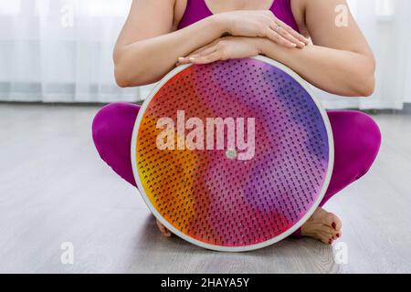 Frau sitzt neben dem Brett mit Nägeln. Yogi-Frau. Die Beine aus der Nähe. Yoga Üben Stockfoto