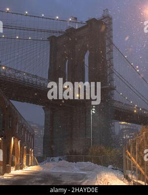 Szenische Aufnahme der Brooklyn Bridge an einem verschneiten Tag in New York City während der Nacht Stockfoto