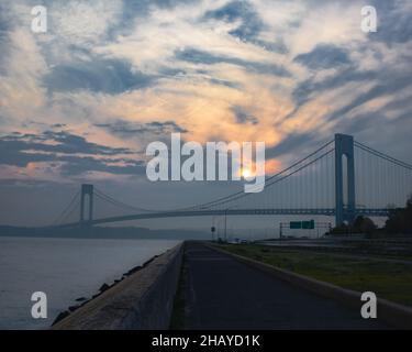 Szenische Aufnahme der Verrazzano-Narrows Suspension Bridge während des farbenfrohen Sonnenuntergangs in New York Stockfoto
