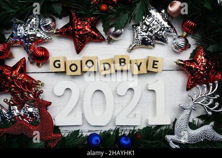 Auf Wiedersehen 2021 Buchstaben und weihnachtsschmuck auf Holzhintergrund Stockfoto