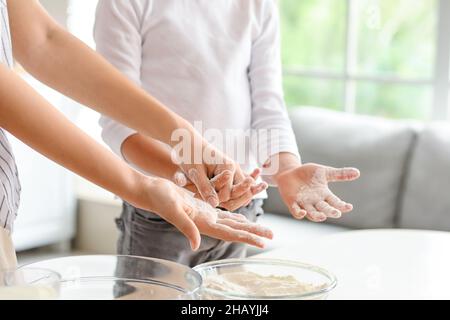 Teenager-Mädchen und ihr kleiner Bruder bereiten Teig in der Küche, Nahaufnahme Stockfoto