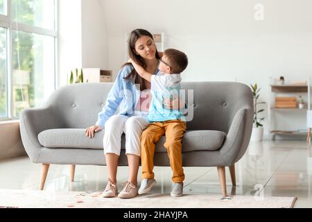 Kleiner Junge mit seiner älteren Schwester umarmt sich zu Hause auf dem Sofa Stockfoto